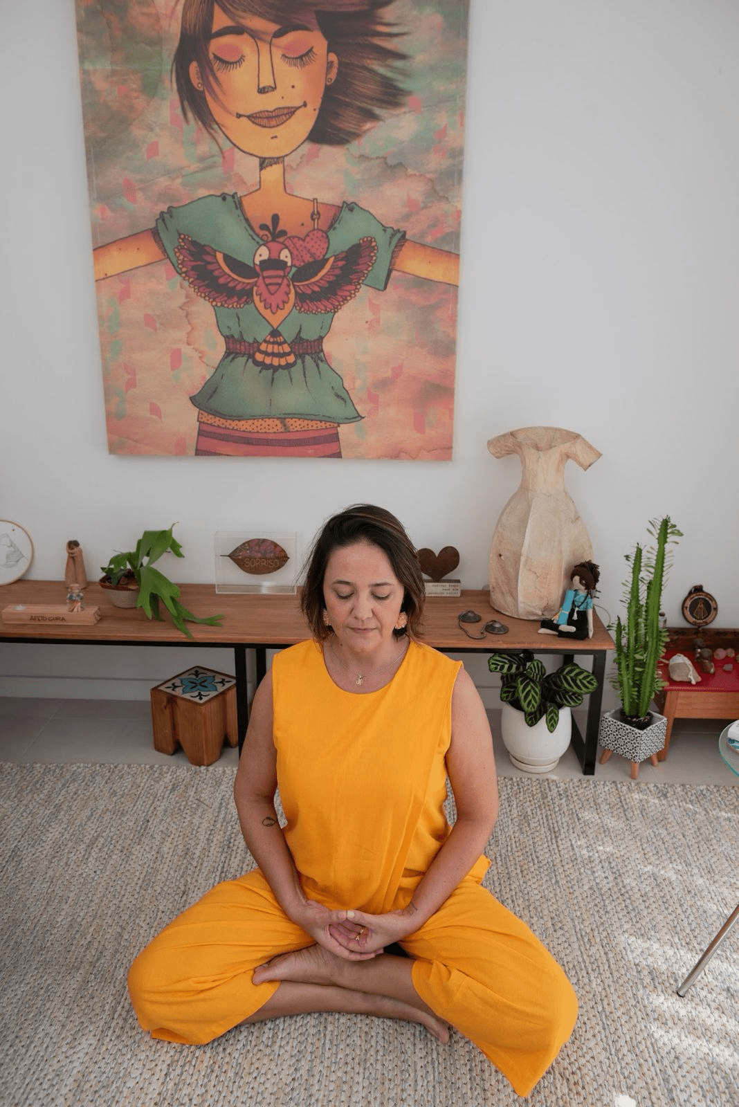 Christine sentada no consultório praticando meditação